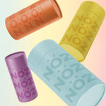 Load image into Gallery viewer, Scattered view of Nöz blue, yellow, orange, and purple tinted sunscreen
